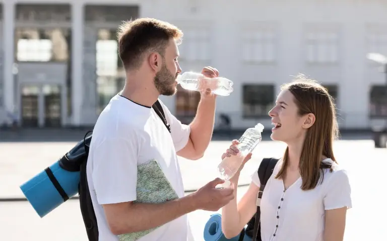 Par na vrućini pije vodu na ulici