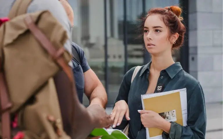 Žena zbunjena stoji na ulici i čeka šta će se dogoditi