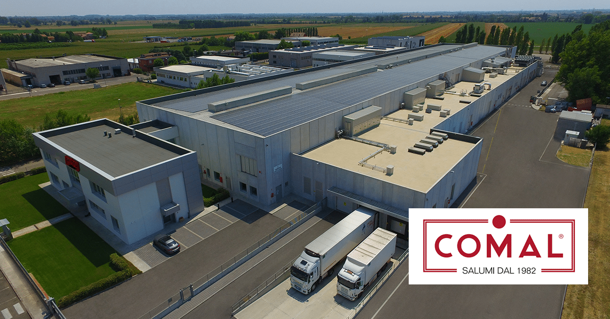 Panoramica aerea di un edificio commerciale Comal con pannelli solari sul tetto.