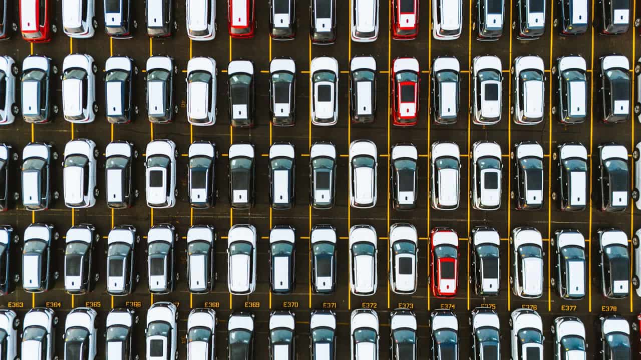An aerial shot capturing a symmetrical layout of parked cars in a parking lot.
