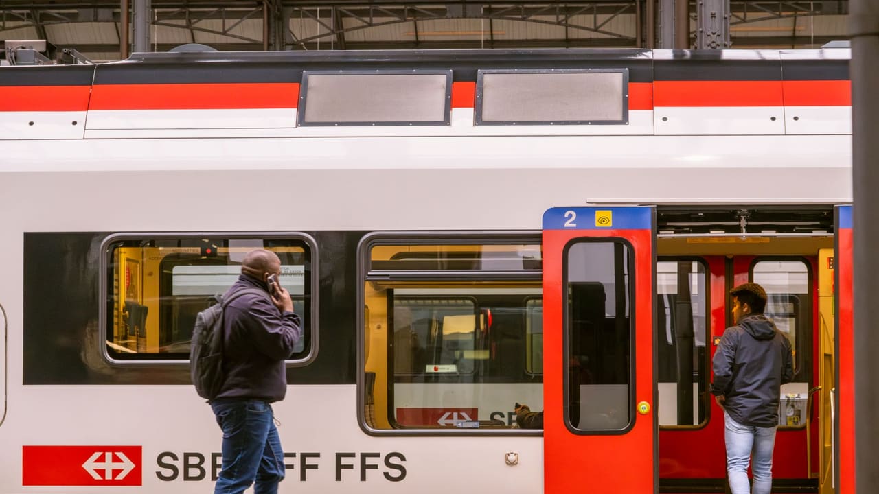 Travelers boarding an SBB train at the Lucerne railway station in Switzerland.