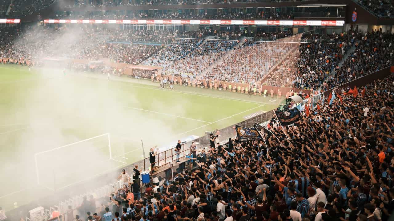 A vibrant scene of a packed soccer stadium with enthusiastic fans cheering during a match.