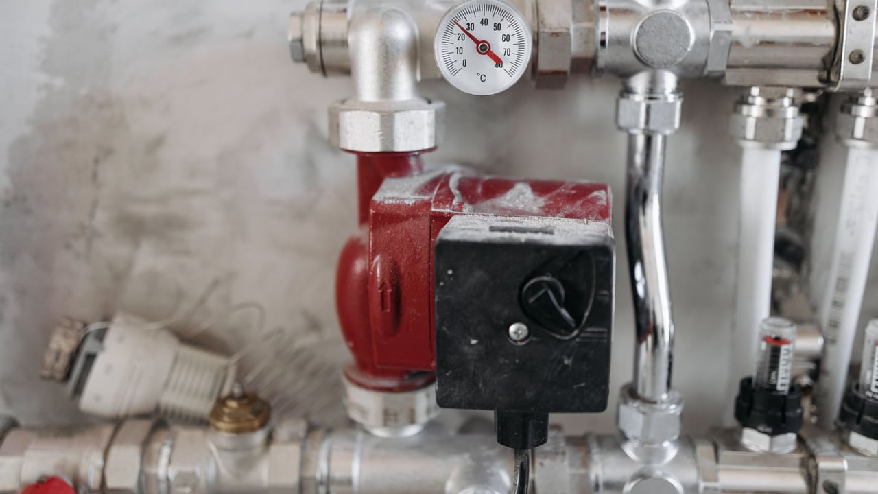 Close-up view of an industrial plumbing system featuring a pressure gauge and steel pipes.