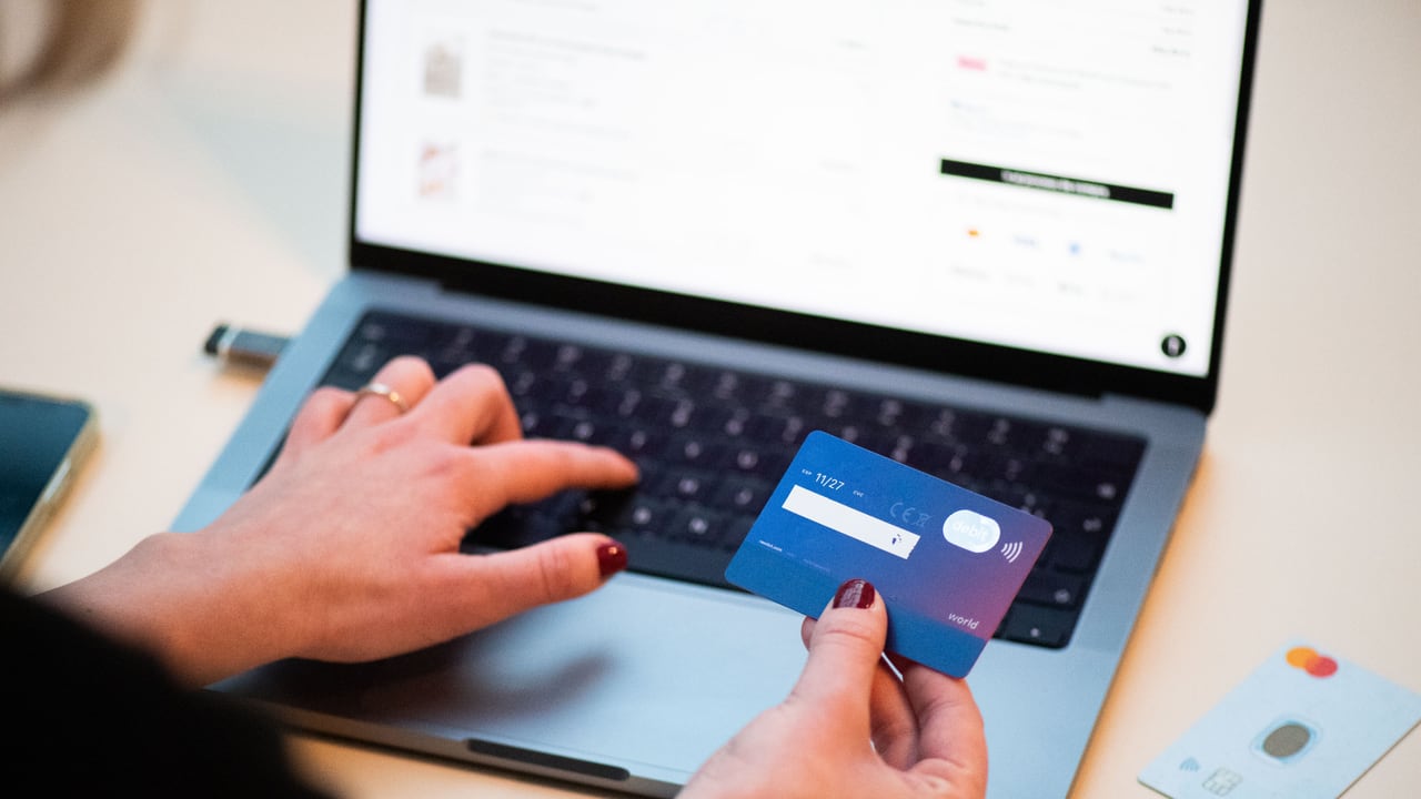 A person using a bank card to shop online
