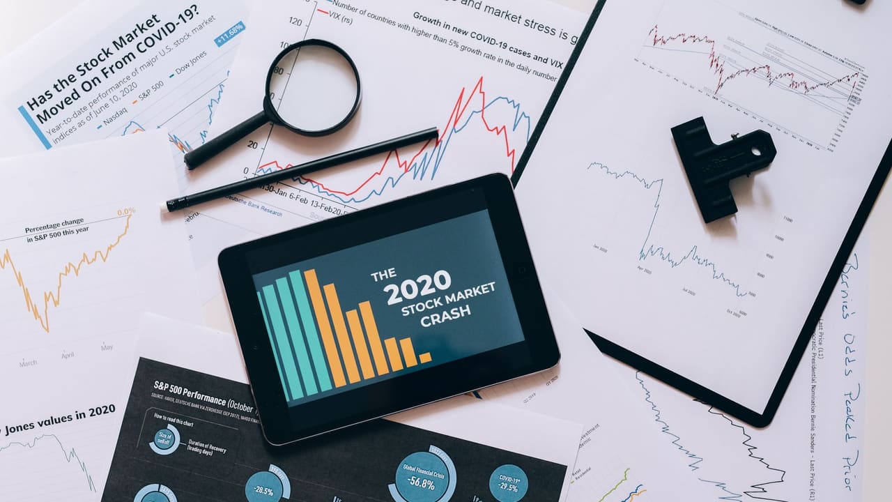 Tablet displaying 2020 stock market crash amidst graphs and charts. Perfect for financial analysis themes.