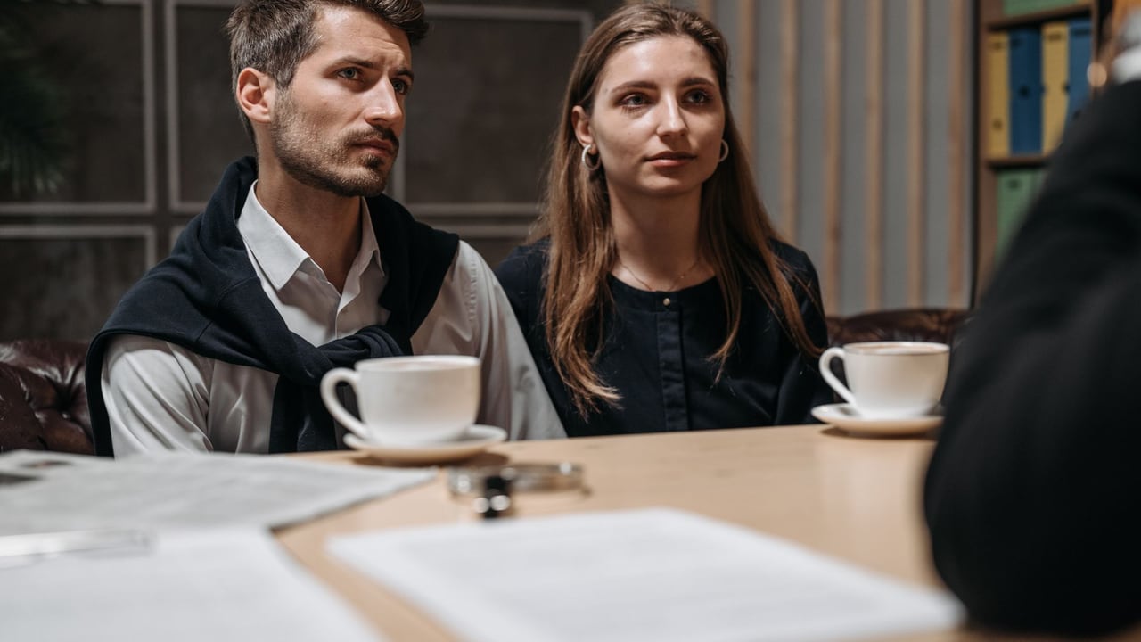 Business meeting with a couple engaging with a consultant in a modern office setting.