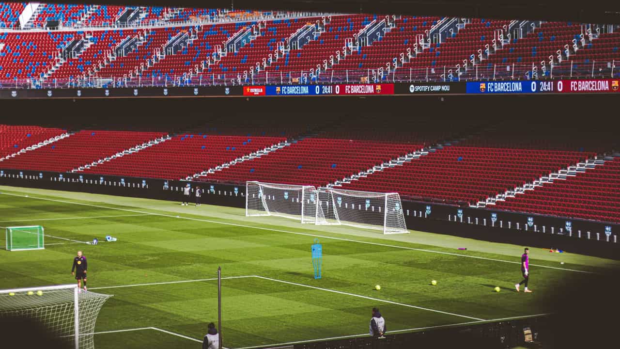 View of empty soccer field at FC Barcelona's Camp Nou with training equipment.