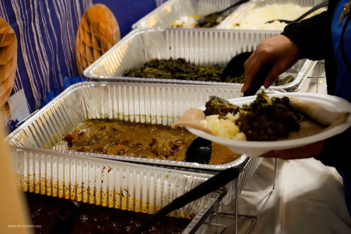 Savory stews and vibrant greens served buffet-style, showcasing a delicious selection of traditional dishes.