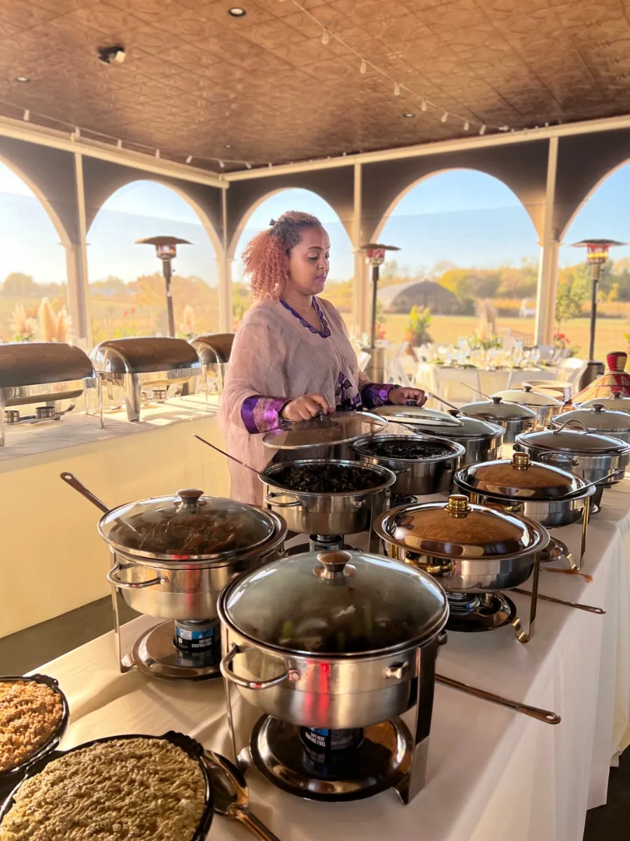 Buffet setup featuring a variety of dishes under elegant lighting, all in a beautiful outdoor dining space.