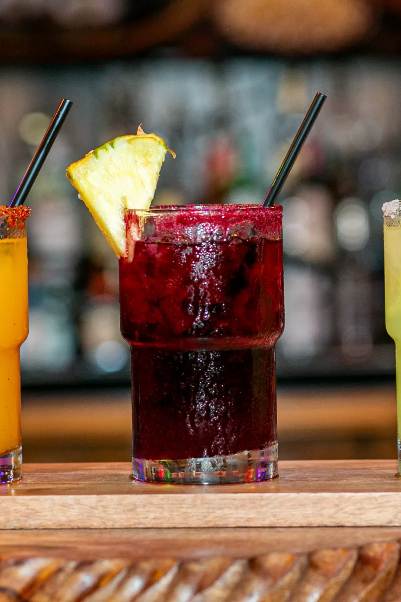 Vibrant cocktails with colorful garnishes, perfect for a refreshing drink in a lively setting.