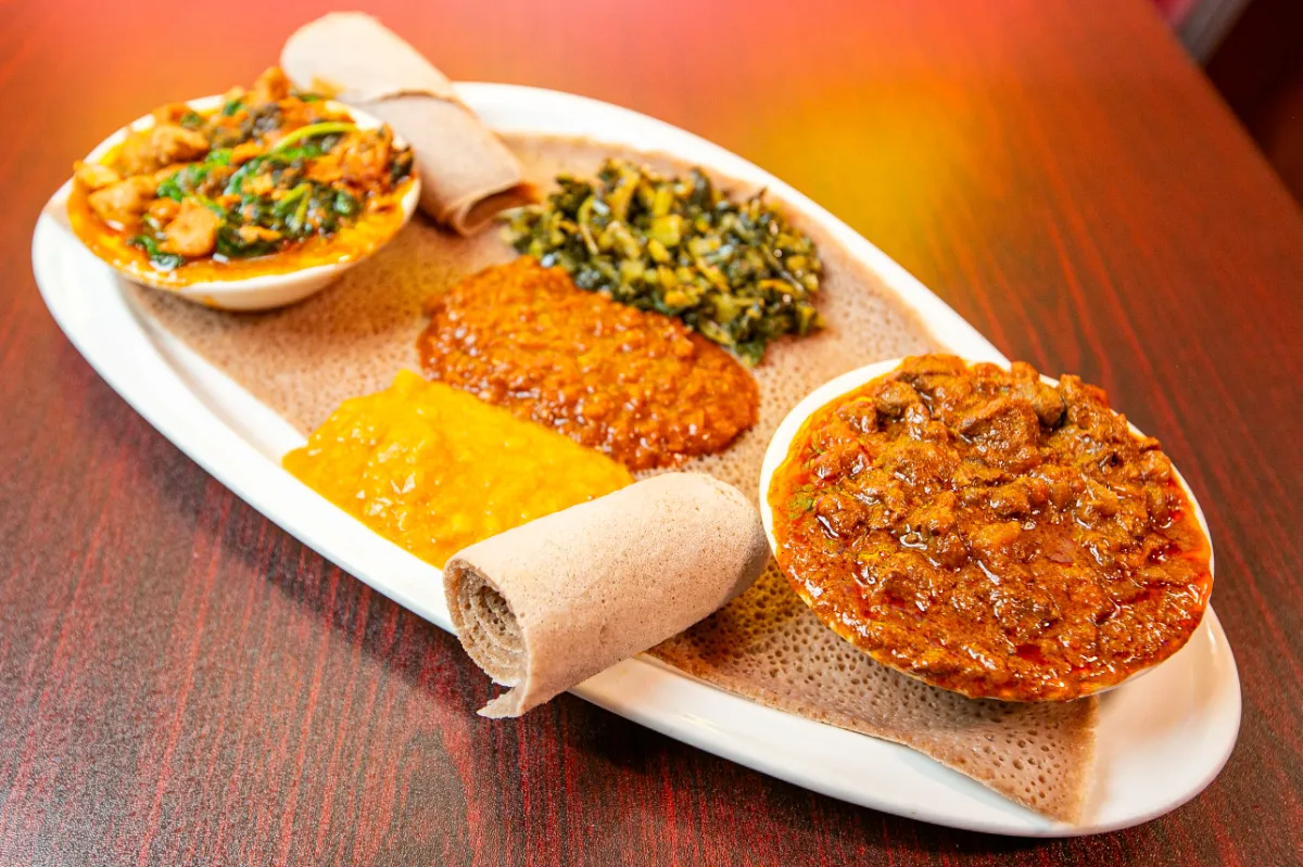 Authentic Ethiopian platter with colorful stews and spiced vegetables served on traditional injera, perfect for sharing.