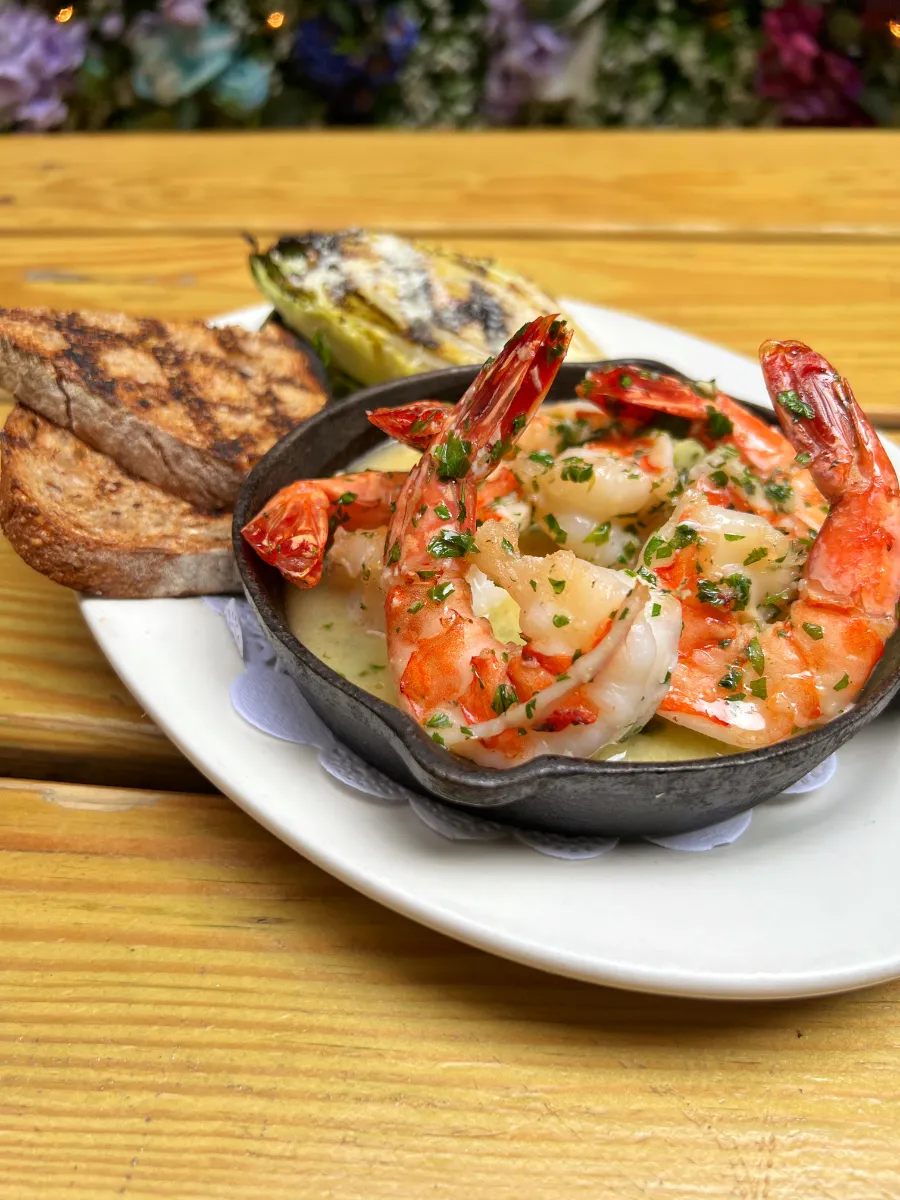 Delicious shrimp scampi served at Loreley Beer Garden in NYCs Lower East Side, 10002. Perfect for dining in a vibrant atmosphere, this dish features succulent shrimp in a garlic butter sauce, accompanied by grilled bread. Ideal for food lovers exploring top restaurant options near Nolita, SoHo