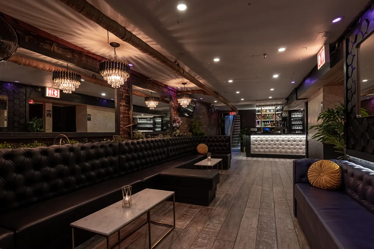 Stylish interior of Loreley Beer Garden featuring cozy black tufted seating, elegant chandeliers, and a sleek bar area. Ideal venue for gatherings such as birthdays and engagement parties in NYCs Lower East Side (10002).