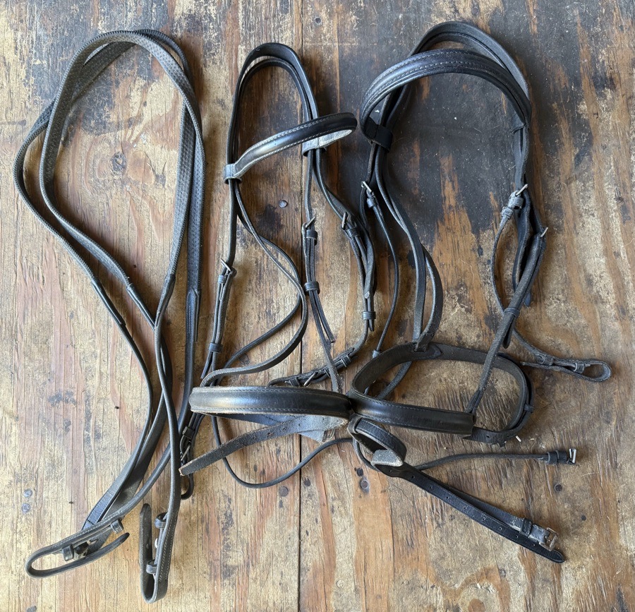 lot of black bridles and reins