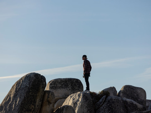 a man standing on top of a rock formation