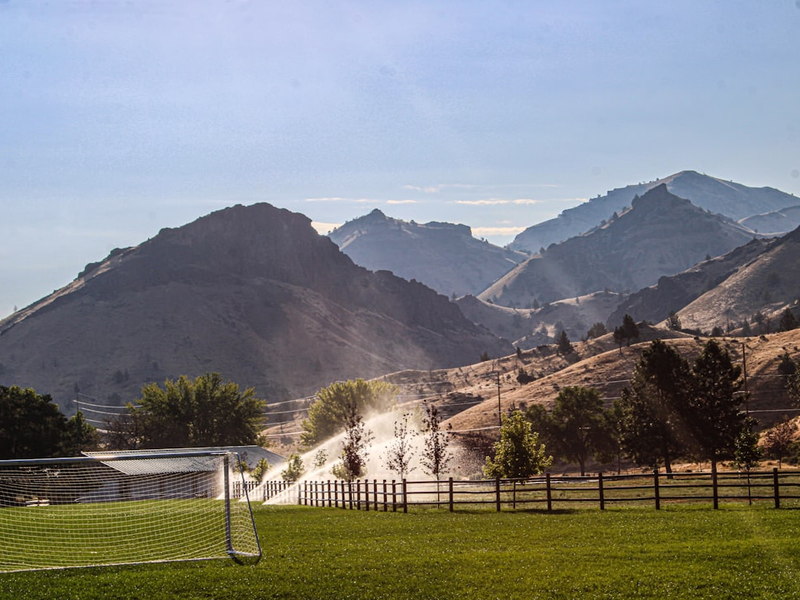A soccer field with mountains in the background
