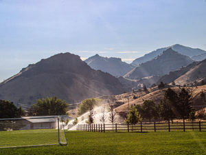 A soccer field with mountains in the background