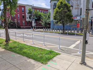 Flexpost delineators prevent cars from parking on the curbside of R Street NE's unit block in Washington, D.C. These no-parking zones increase the safety of walking and biking by improving the visibility of motorists sharing space with those pedestrians and cyclists.