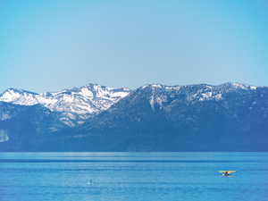 person riding on boat on sea near snow covered mountain during daytime