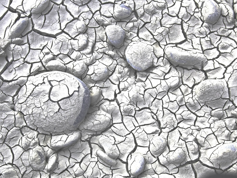 Dried and cracked mud/sand on a tidal riverbank. The low rainfall has lowered the river level.