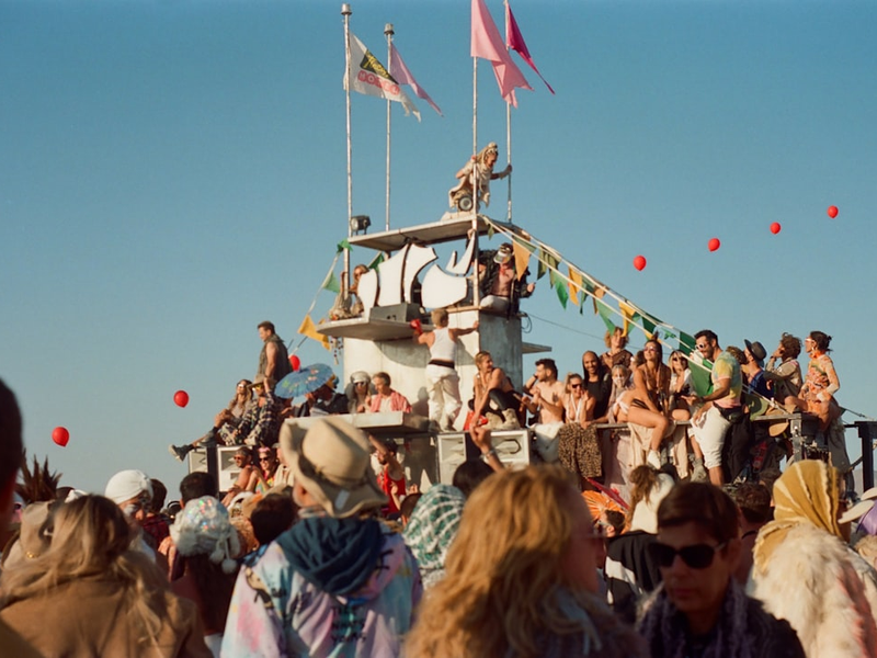 a crowd of people standing on top of a boat