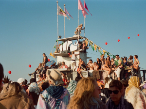 a crowd of people standing on top of a boat