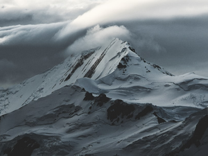 snow covered mountain under white clouds