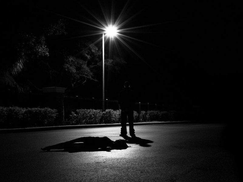 a person laying on the ground under a street light