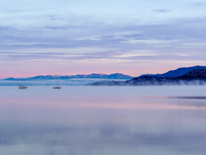 boats on body of water near mountain during daytime