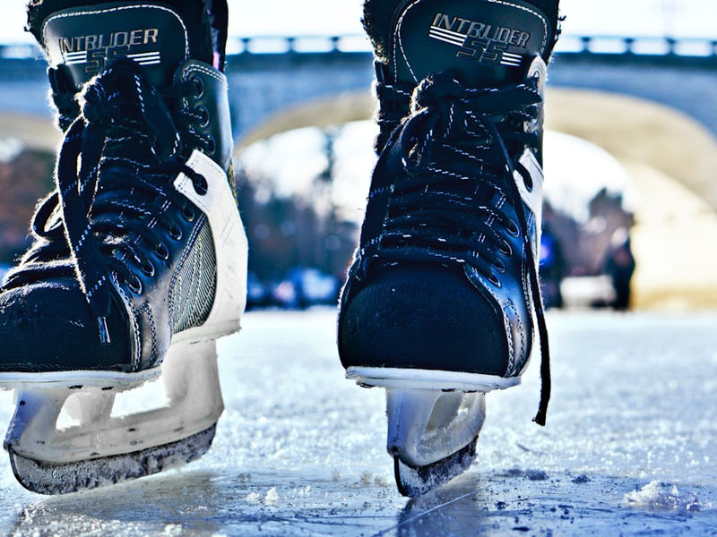 close-up photo of black-and-gray Intruder ice skates on frozen body of water