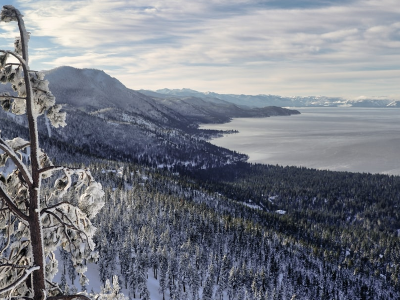 a view of a snowy mountain with a lake in the distance