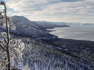 a view of a snowy mountain with a lake in the distance