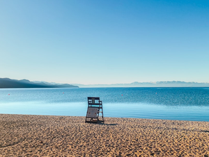 a chair sitting on the beach next to the ocean