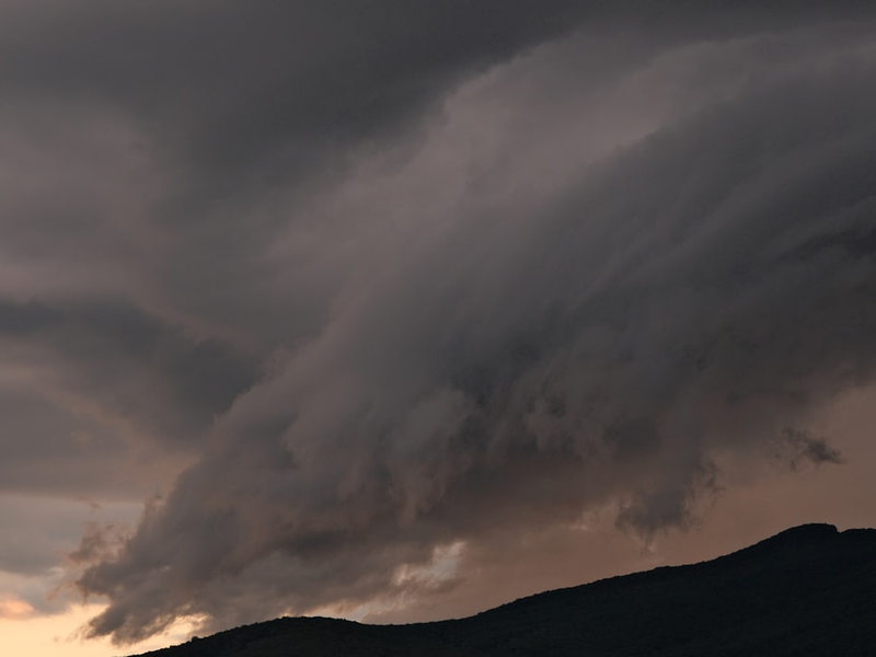 Storm clouds gathering above a hill.