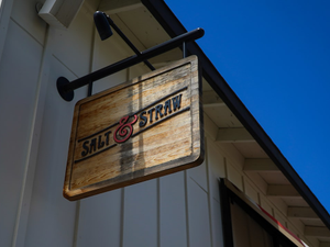 a wooden sign hanging from the side of a building