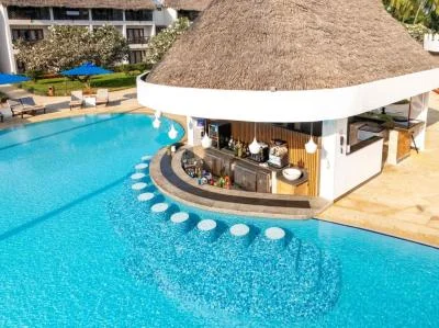 Outdoor resort swimming pool featuring a built-in swim-up bar and thatched roof.