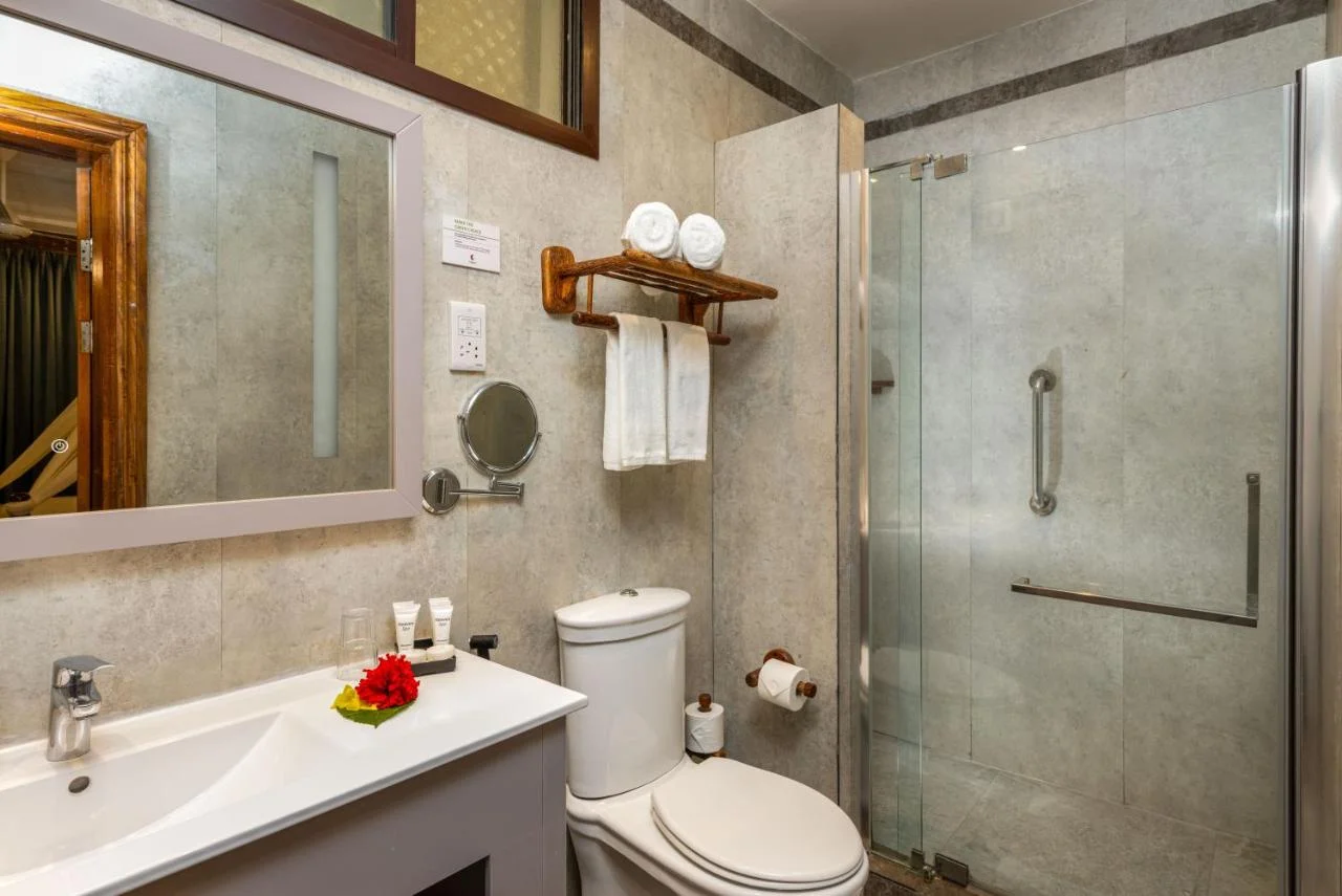 Clean and modern hotel bathroom featuring a glass shower and vanity sink.
