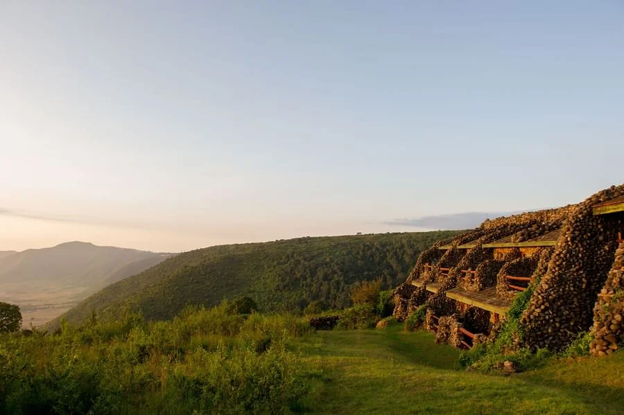 Native stone lodge facade built into the lush green hillside at Ngorongoro Serena Safari Lodge.