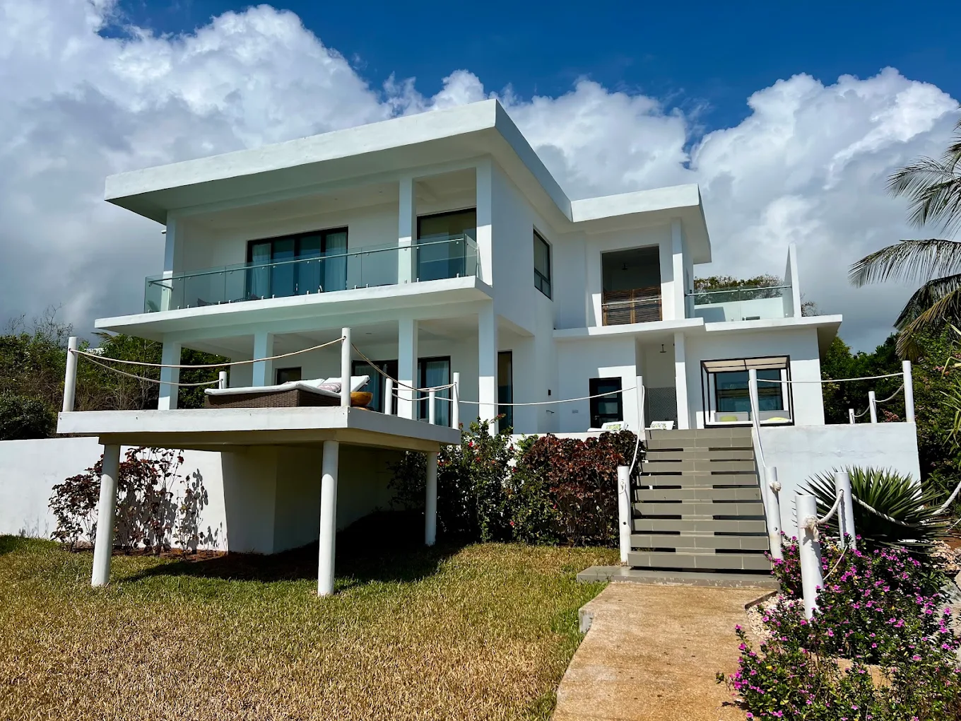 Contemporary white luxury villa architecture and green lawn at Safira Blu Luxury Resort