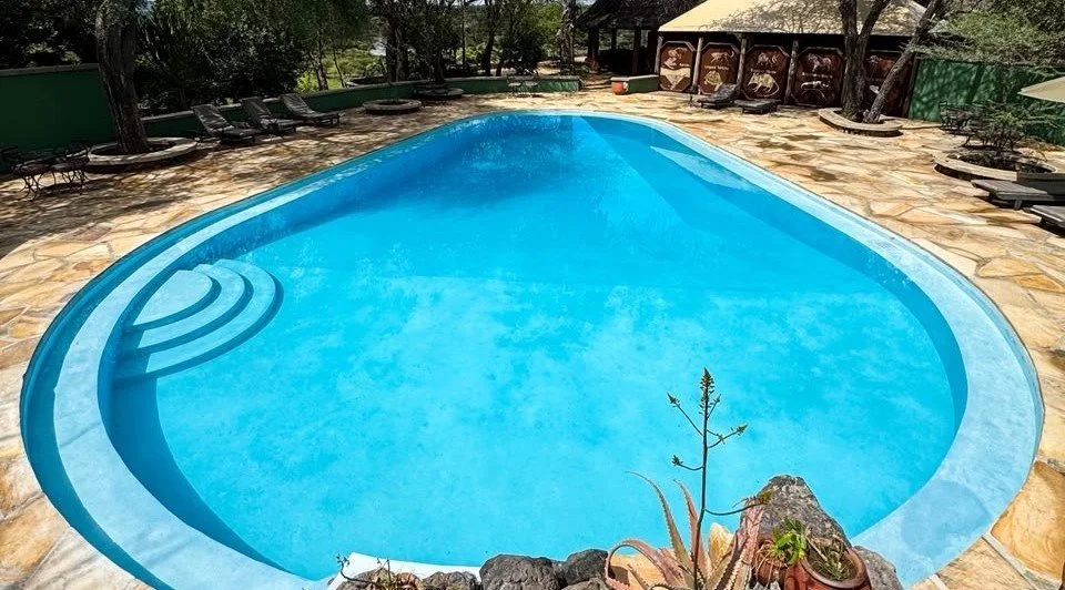 Thatched open-air lounge deck with comfortable chairs overlooking the vast Tarangire valley landscape.