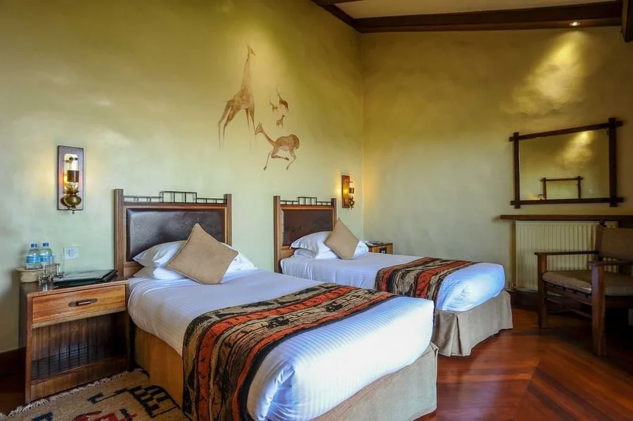 Cozy twin guest bedroom featuring traditional patterned bedspreads at Ngorongoro Serena Safari Lodge.