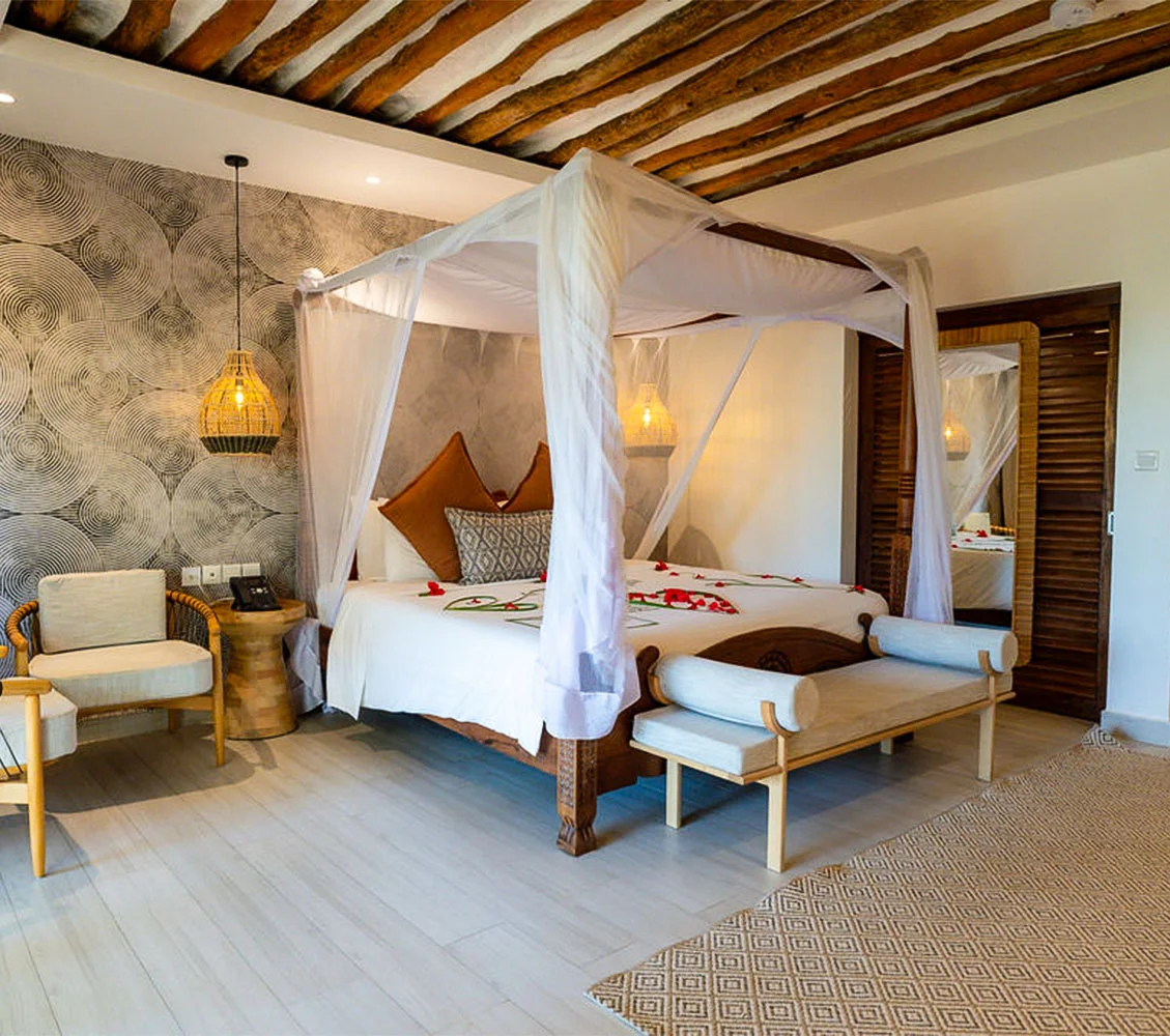 Elegant hotel suite interior featuring a draped canopy bed and traditional decor.