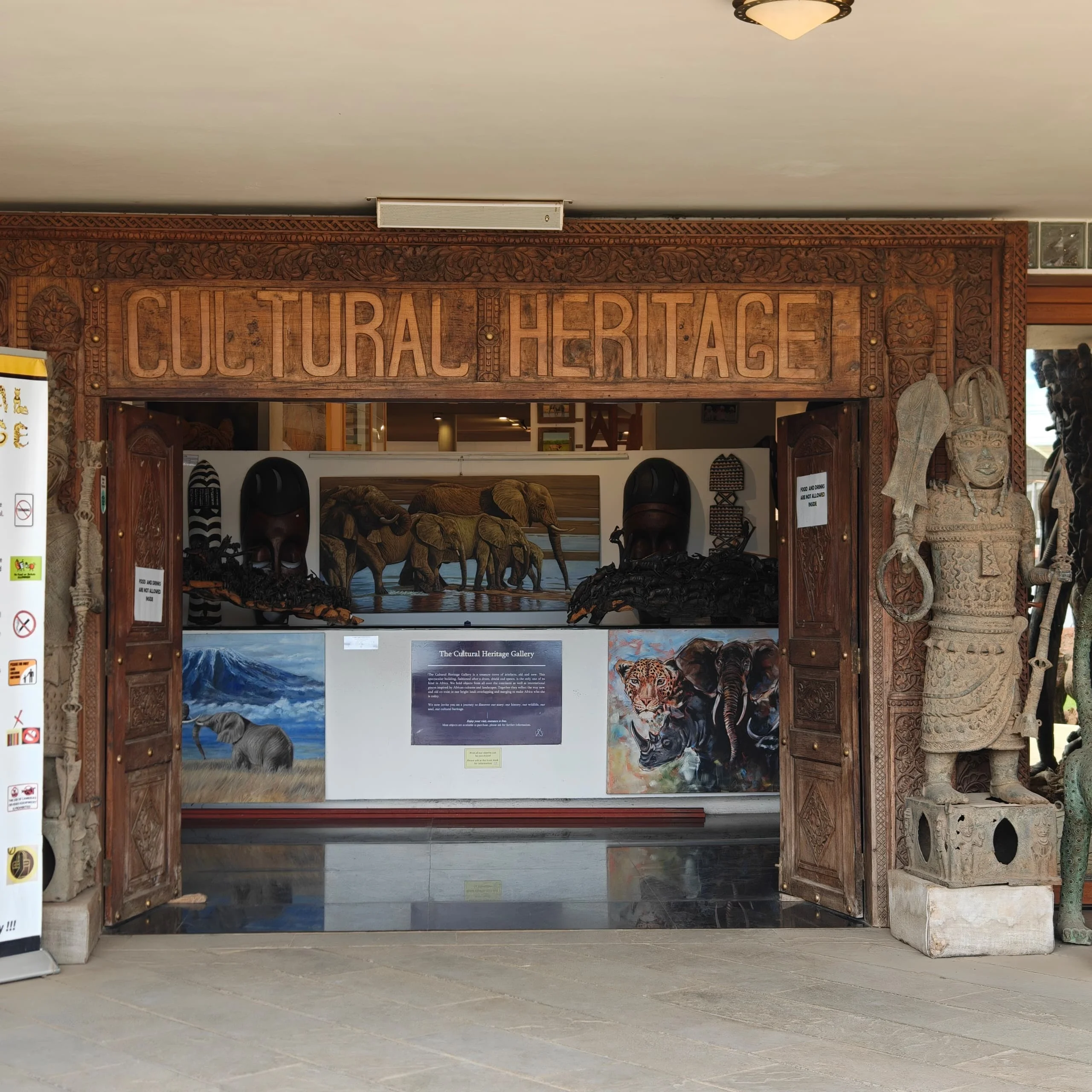 Entrance to the Cultural Heritage Centre in Arusha featuring wooden carved doorways and decorative traditional figures.