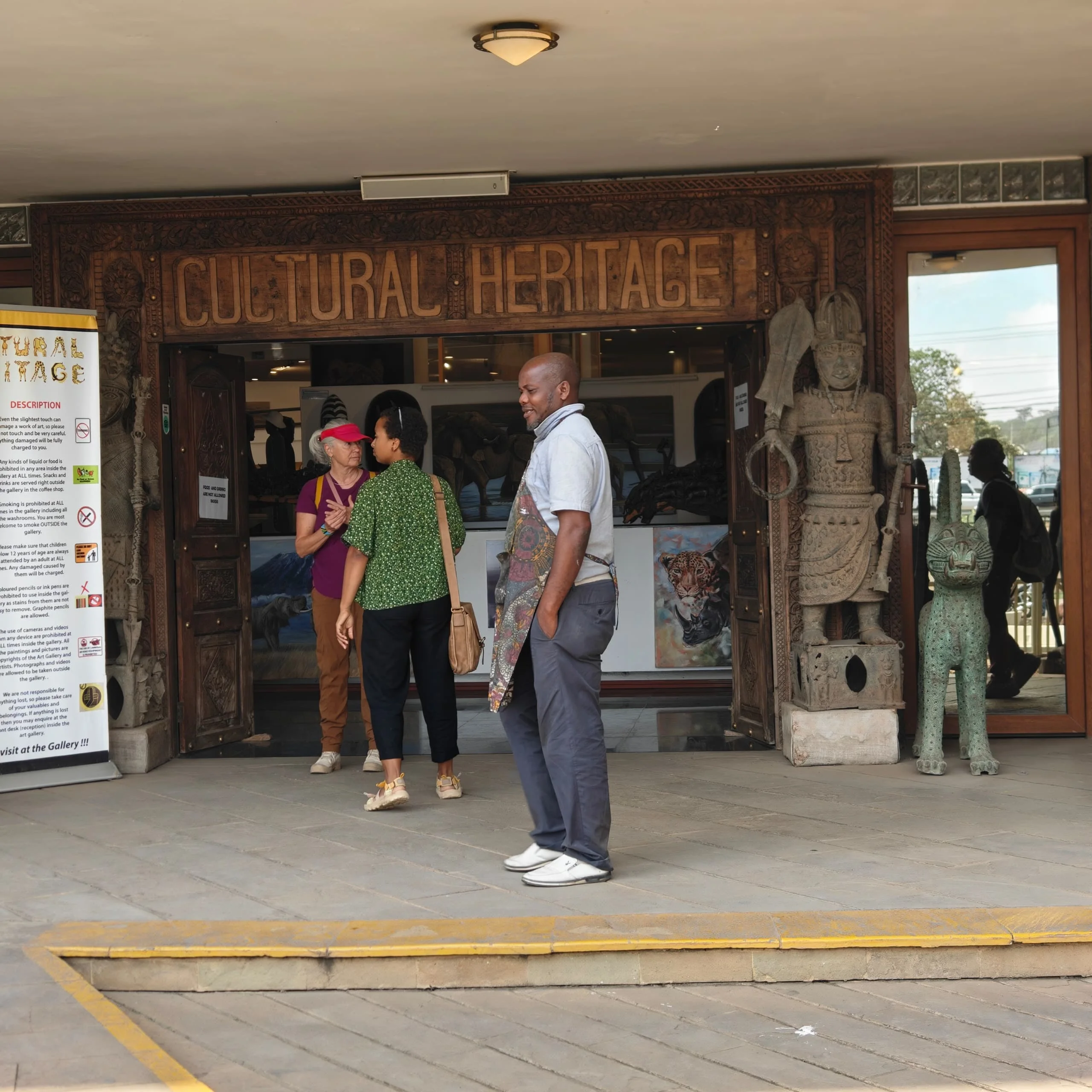 Visitors standing in front of the carved wooden entrance structure at Cultural Heritage Centre Arusha.