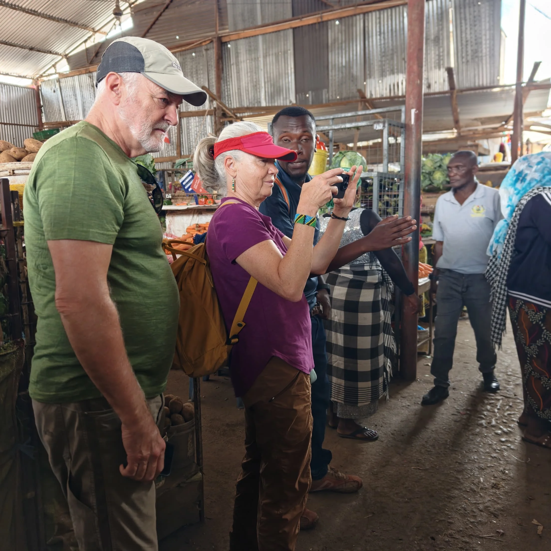 Visitors chatting with vendors inside the covered stalls of Arusha Central Market.