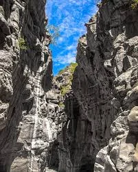 Vertical rock canyon walls and blue sky inside Olkarien Gorge in Ngorongoro Conservation Area, Tanzania.