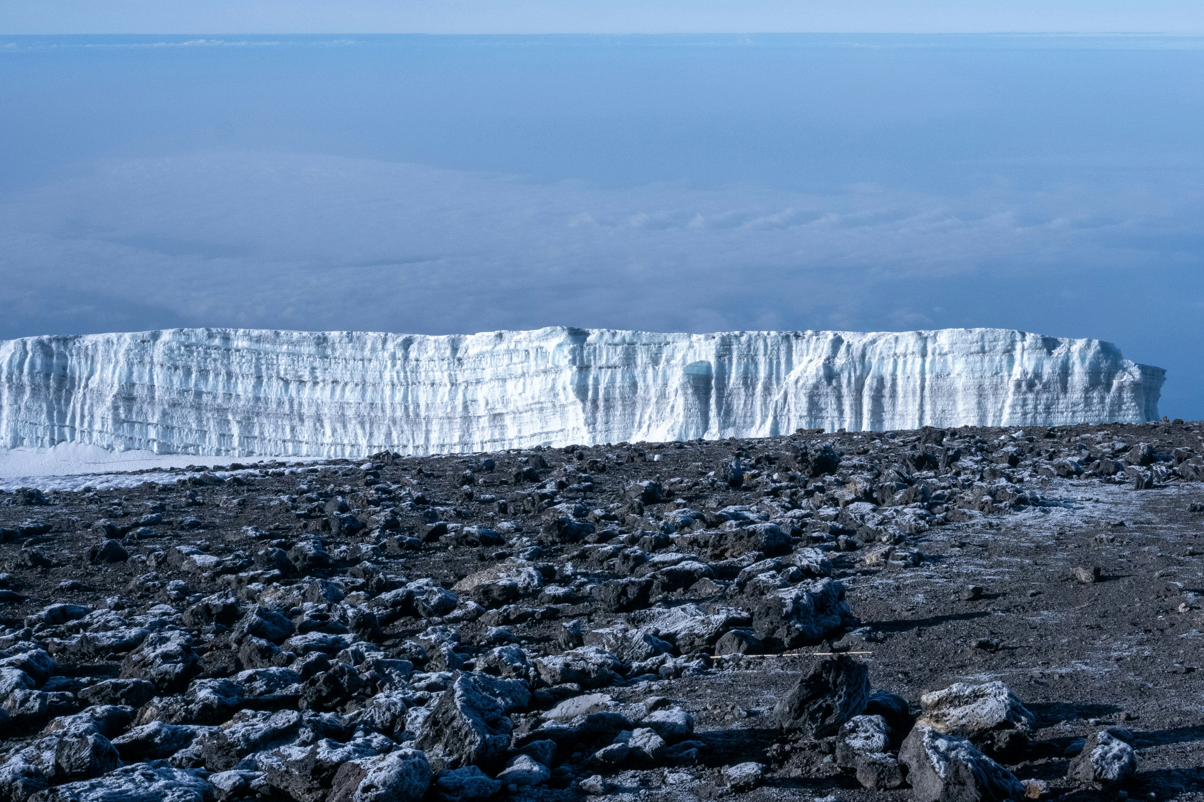 Mount Kilimanjaro glaciers rise above a rocky alpine landscape near the summit along Tanzania's Marangu Route trekking trail.