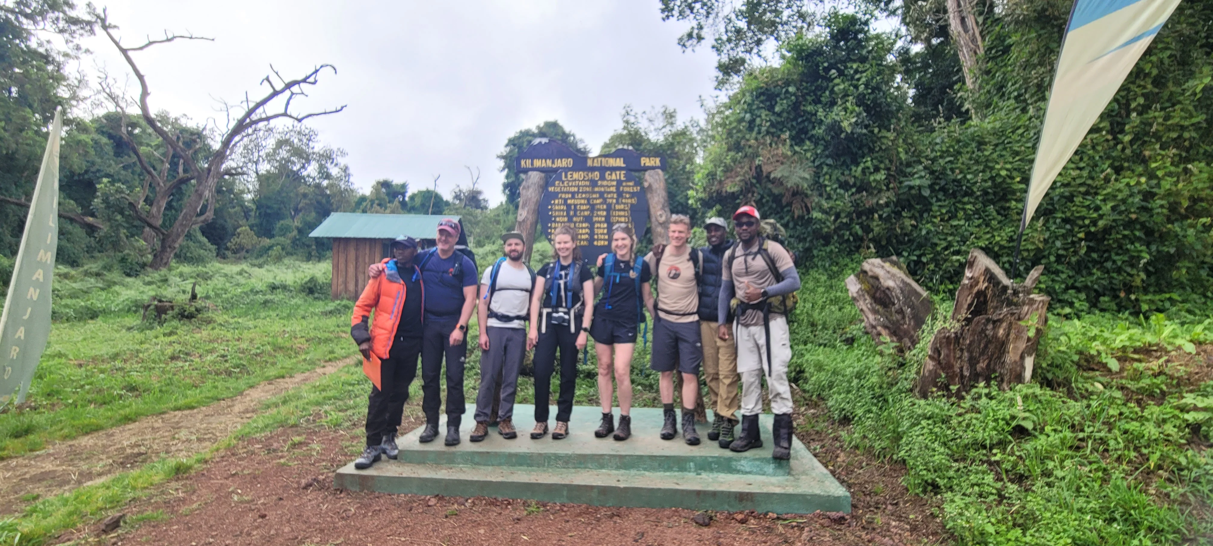 Trekkers pose at a Kilimanjaro National Park trailhead before beginning their Mount Kilimanjaro hiking adventure in Tanzania.