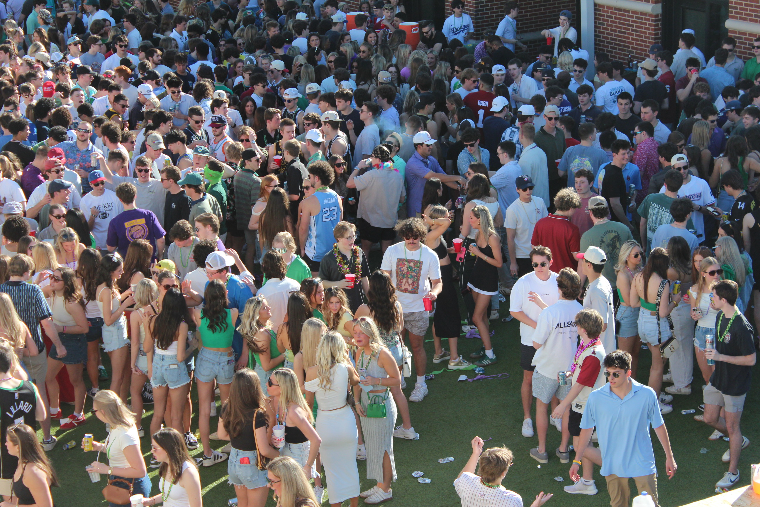 Students at a campus tailgate on artificial turf