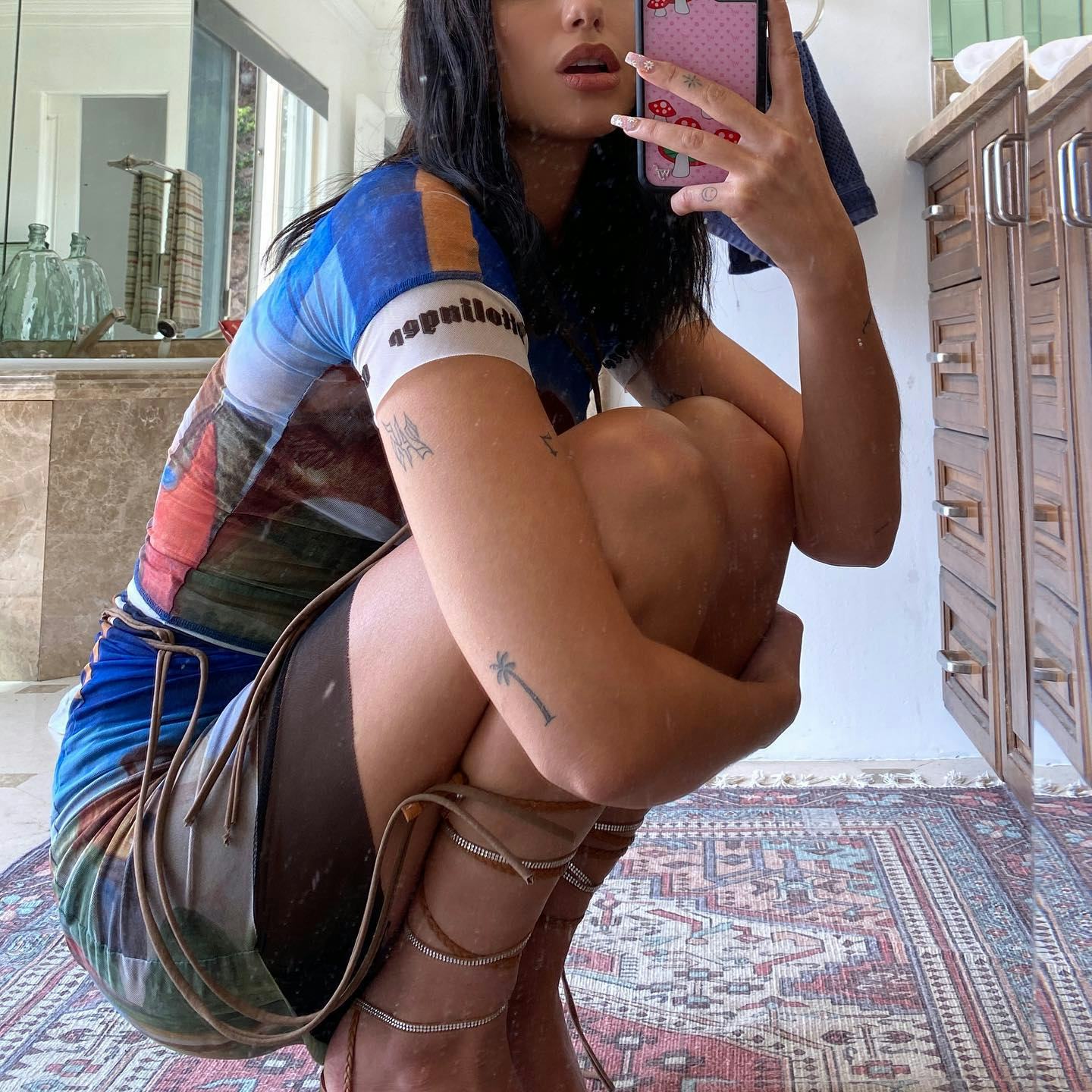 Dua Lipa’s mirror selfie shows the complete small palm tree above her left elbow.